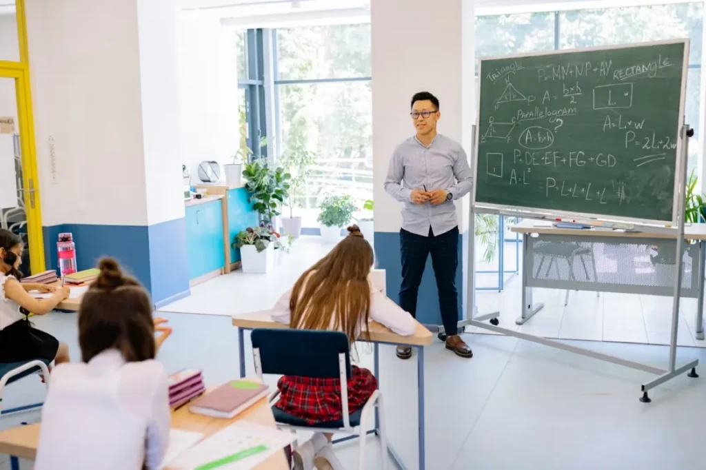 Lecturer at a chalkboard in front of a small group of students